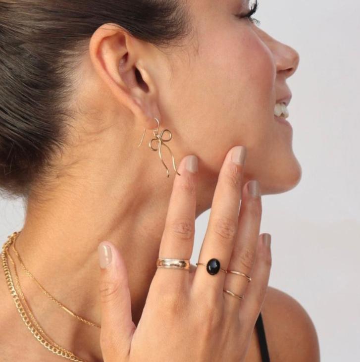 model wearing 14k gold fill hand shaped bow earrings on french ear wire 