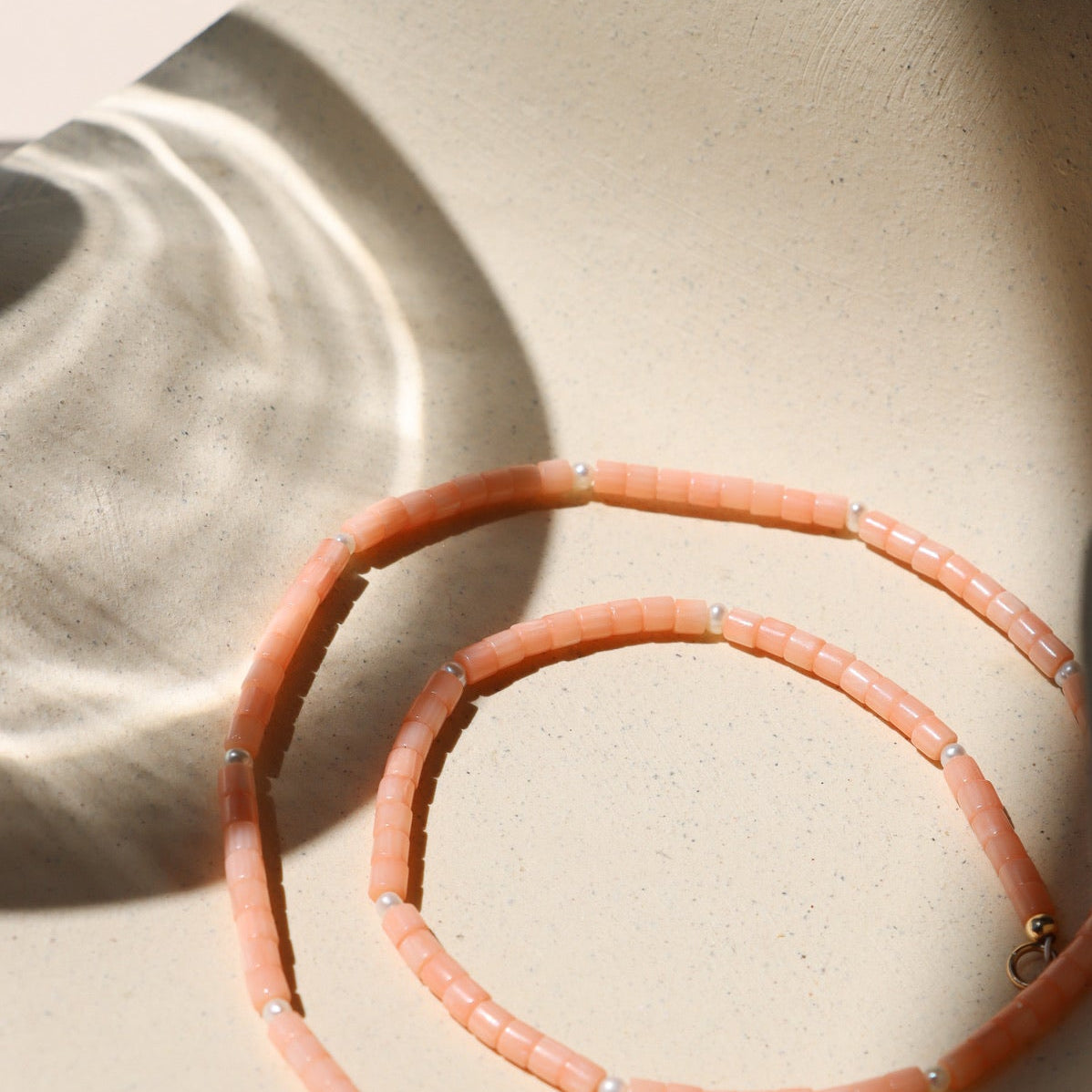 coral and pearl beaded necklace on in the sunshine