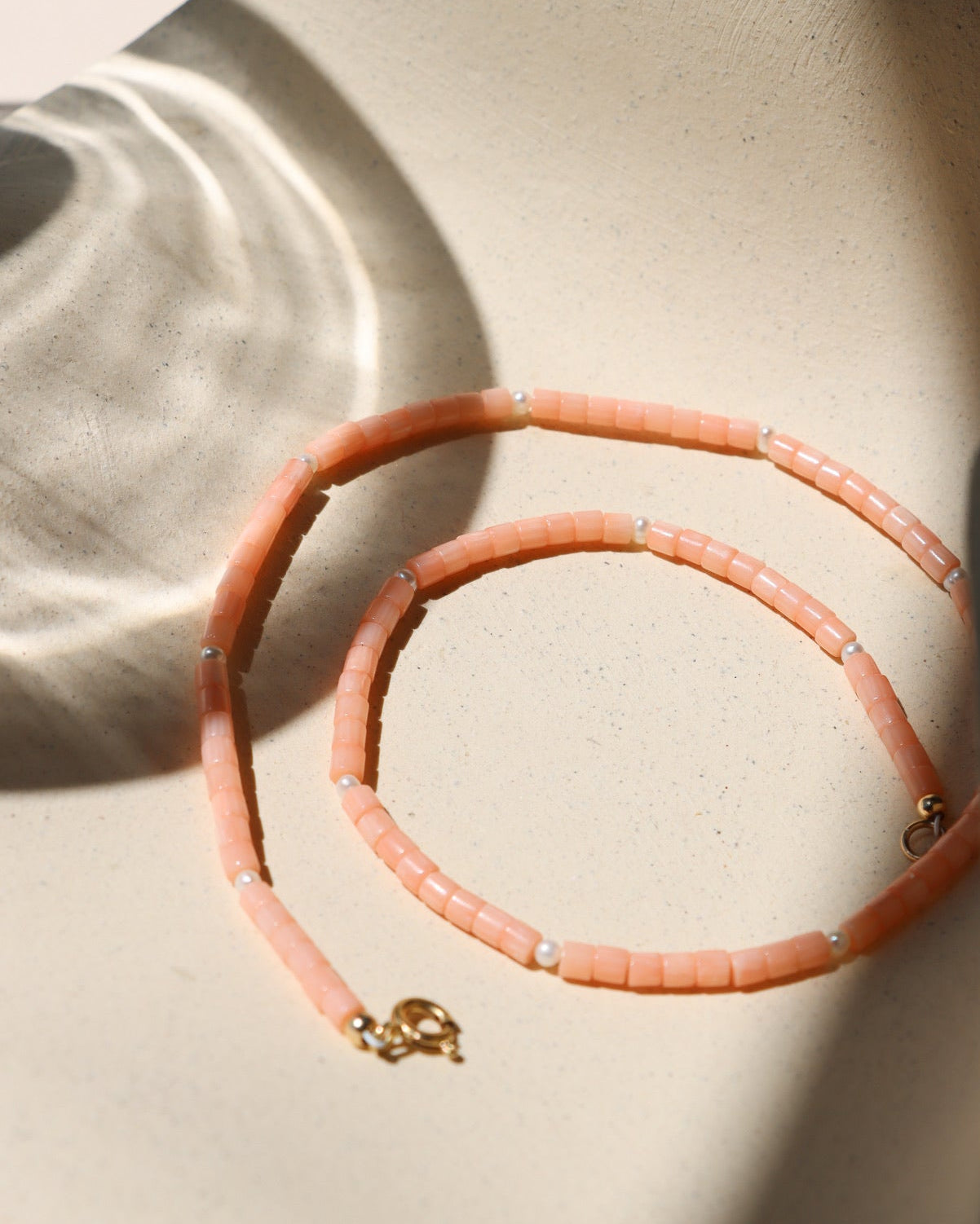 coral and pearl beaded necklace on in the sunshine