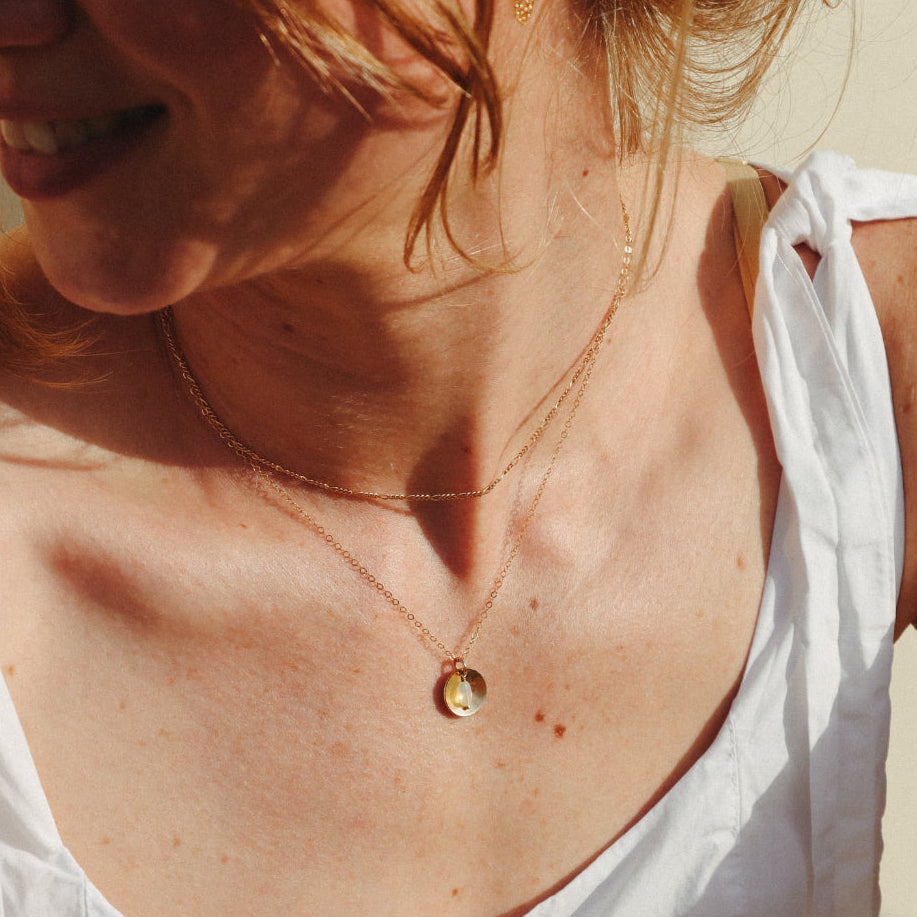 model wearing 14k gold fill delicate chain necklace with opal charm and circle domed charm 