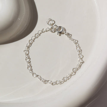 925 sterling silver heart link chain in children's sizes, photographed on a ceramic white plate