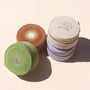 A collection of mini travel jewelry cases with embroidered sun designs, stacked together. They come in beige, green, brown, and purple colors.