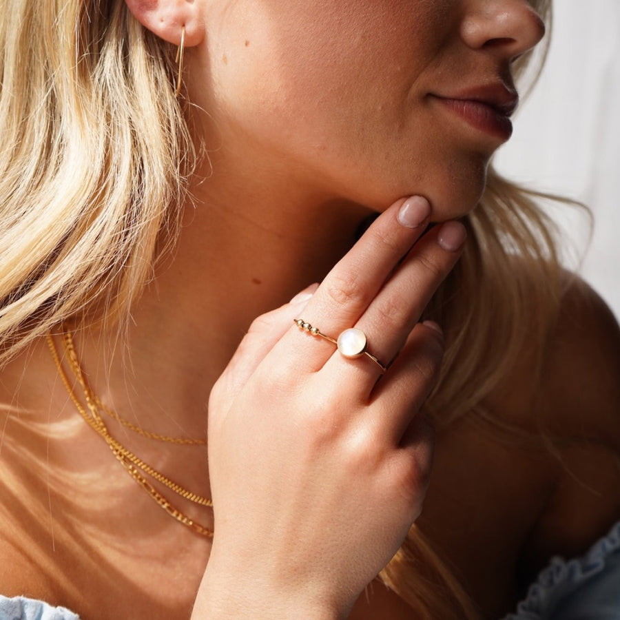 model wearing 14k gold fill meridian fidget ring paired with the moonstone ring