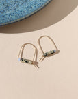 14k gold fill arch shaped earrings with dalmatian jasper & blue lace agate beads on a light background