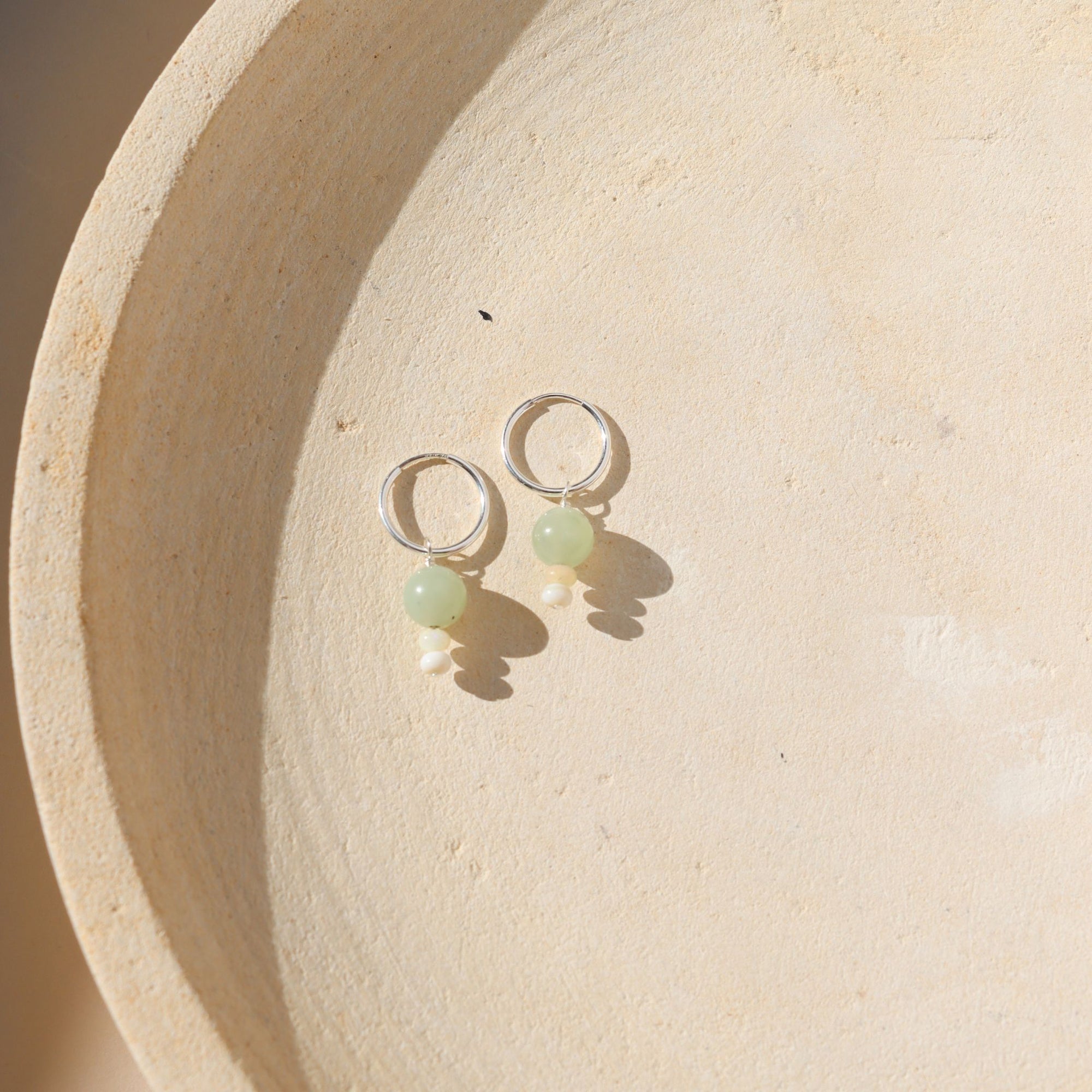 Sterling Silver hoops with chalcedony and ethiopian opal beads on a light dish