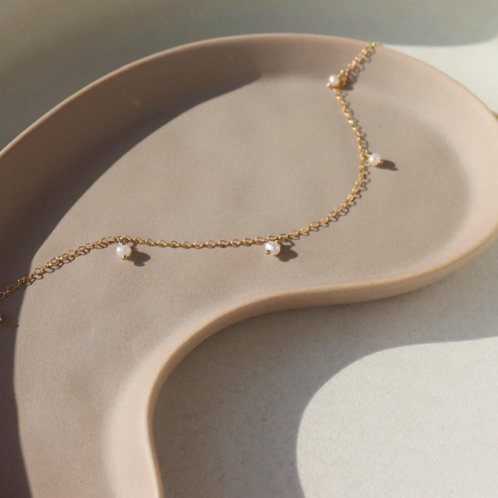 5 sweet little freshwater pearls beautifully anchored on our favorite chain. A classic and simple necklace to wear alone or layer.