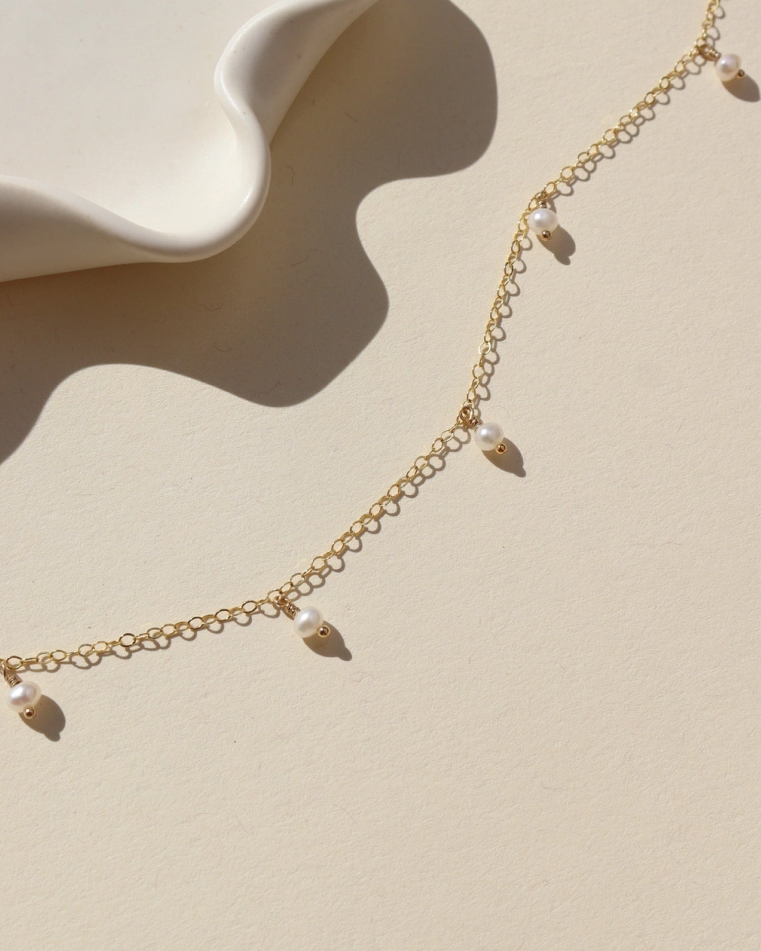 14k gold fill chain necklace with pearls on a light backgound