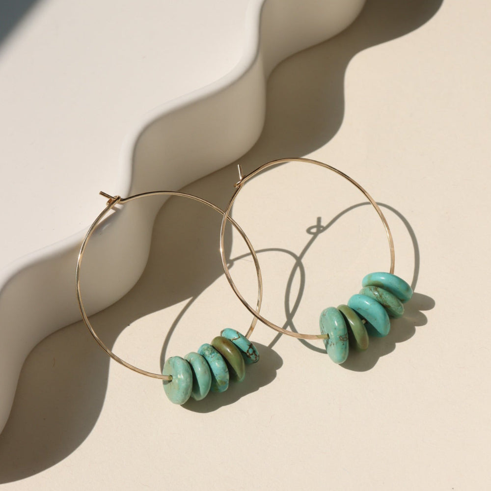Desert Sky Hoops featuring hammered gold filled with teal green turquoise bead accents.