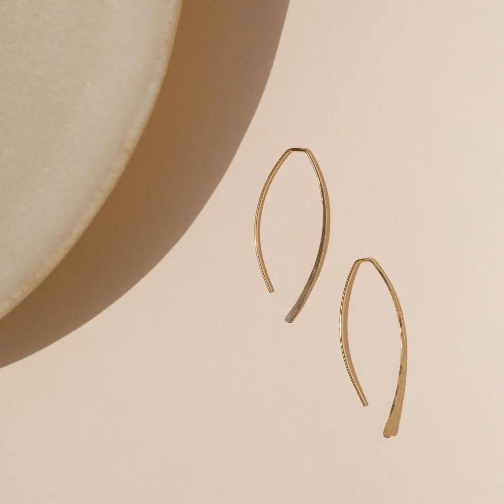 14k gold fill hammered shaped earrings on a light dish