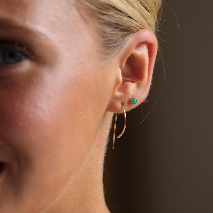model wearing 14k gold fill P shaped threader earrings with emerald stud earrings