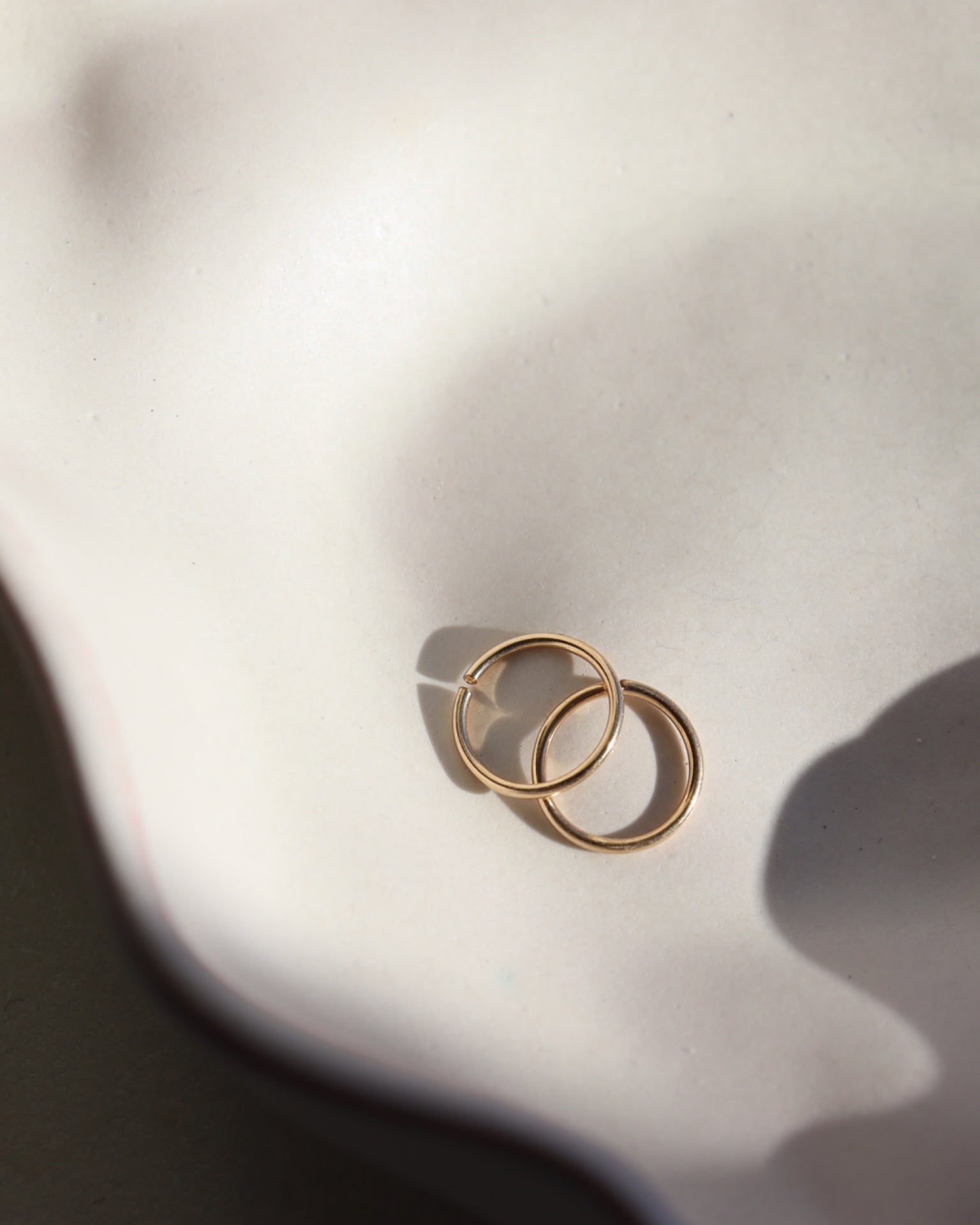 14k solid gold earring set on a white plate, solid gold hoops, 14k solid gold hoops, endless hoops, solid gold hoops, made in the USA, made in wisconsin, eau claire, wi, woman owned business, solid gold jewelry, earrings