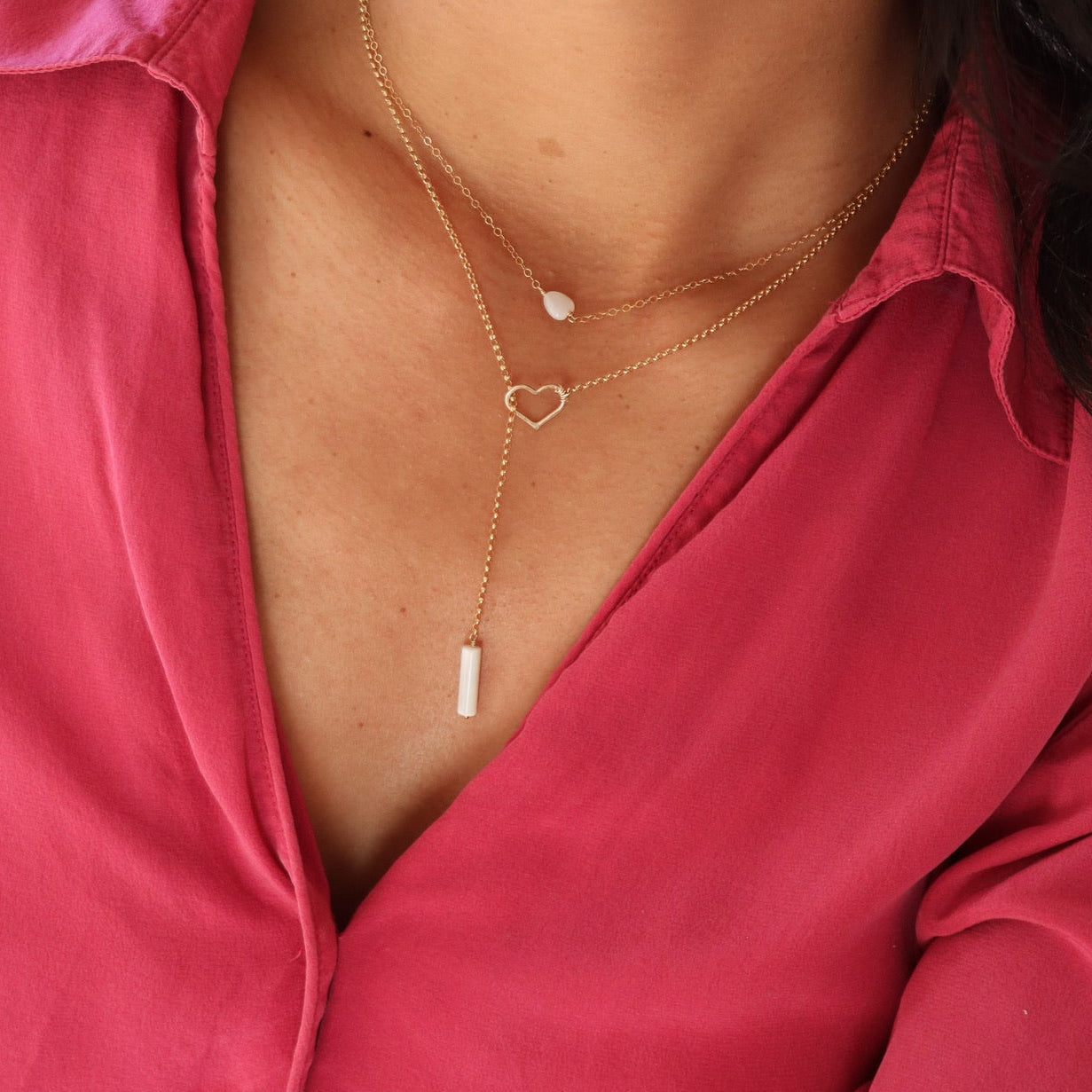 14k gold fill lariat necklace with heart and mother of pearl bead on model layered with mother of pearl heart necklace