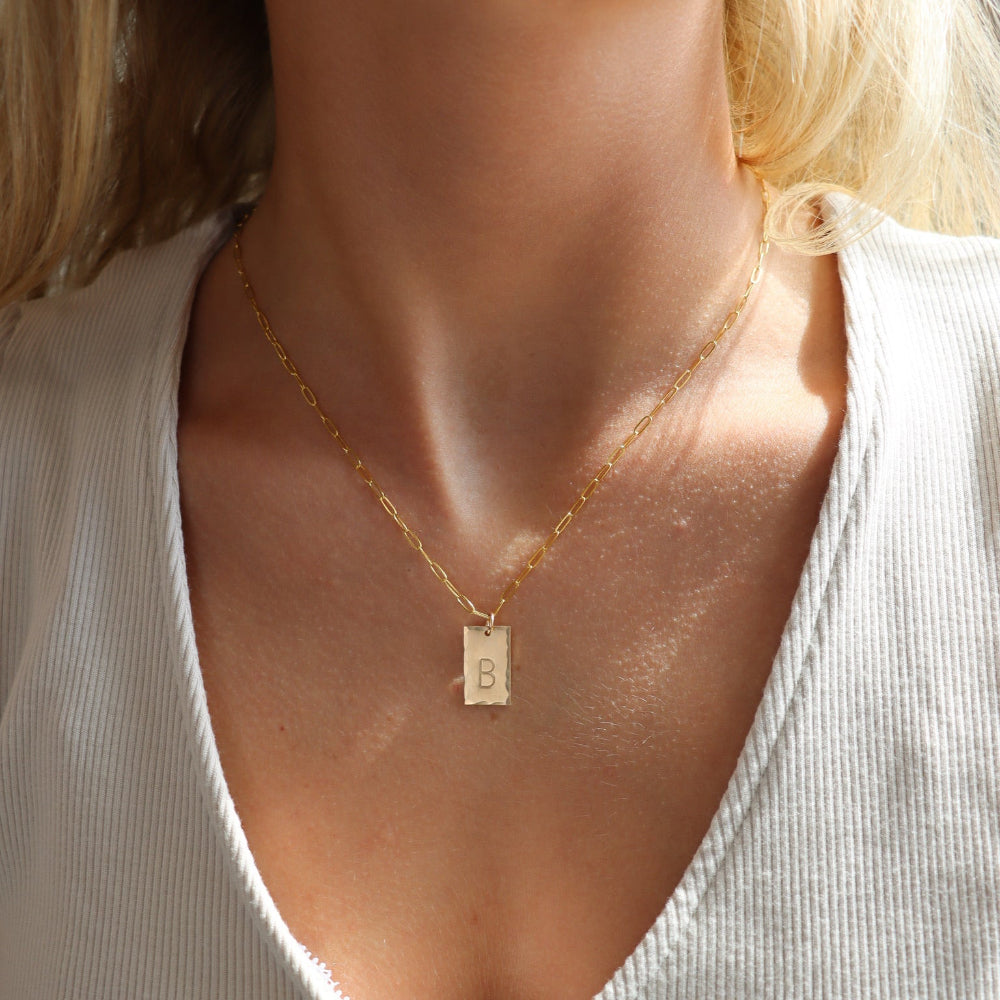 model wearing 14k gold fill hand stamped pendant on a paperclip chain necklace 