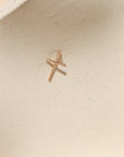 14k gold fill handmade hammered cross charm on a light background