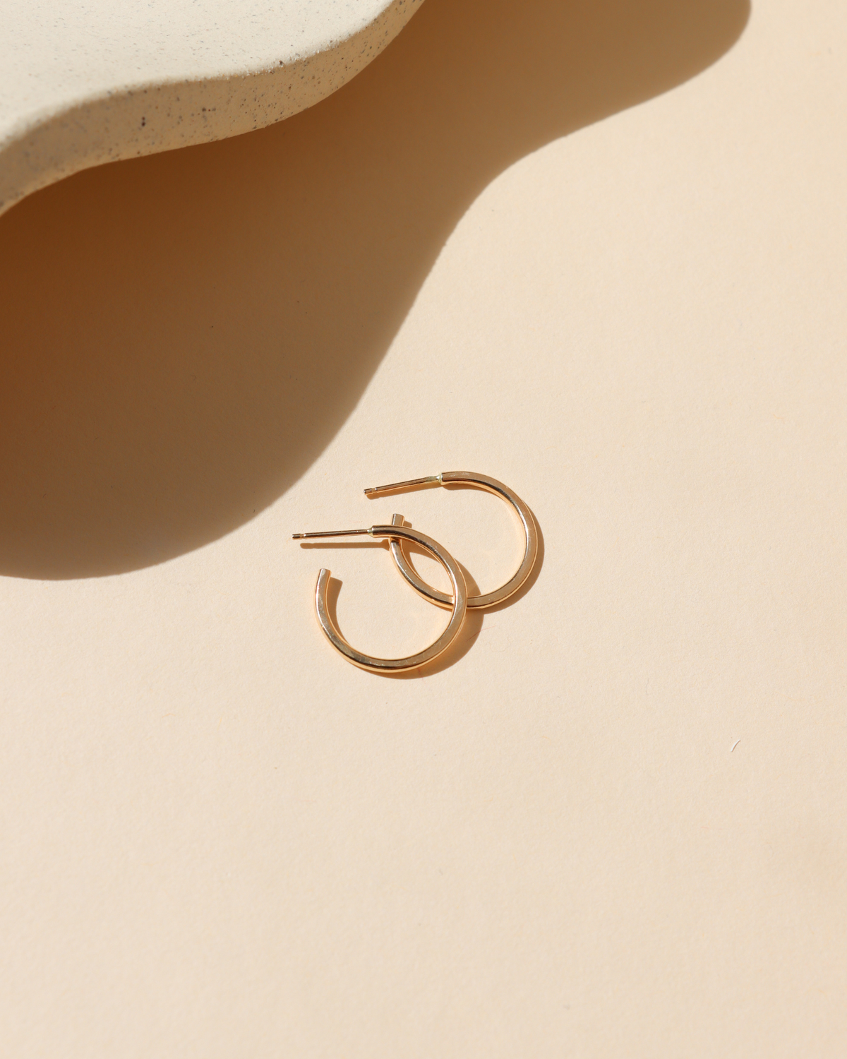 14k Gold Fill Fine Line Hoop Earrings featuring a textured minimalist design, lightweight everyday hoop earrings displayed on a ceramic jewelry tray in warm natural light.