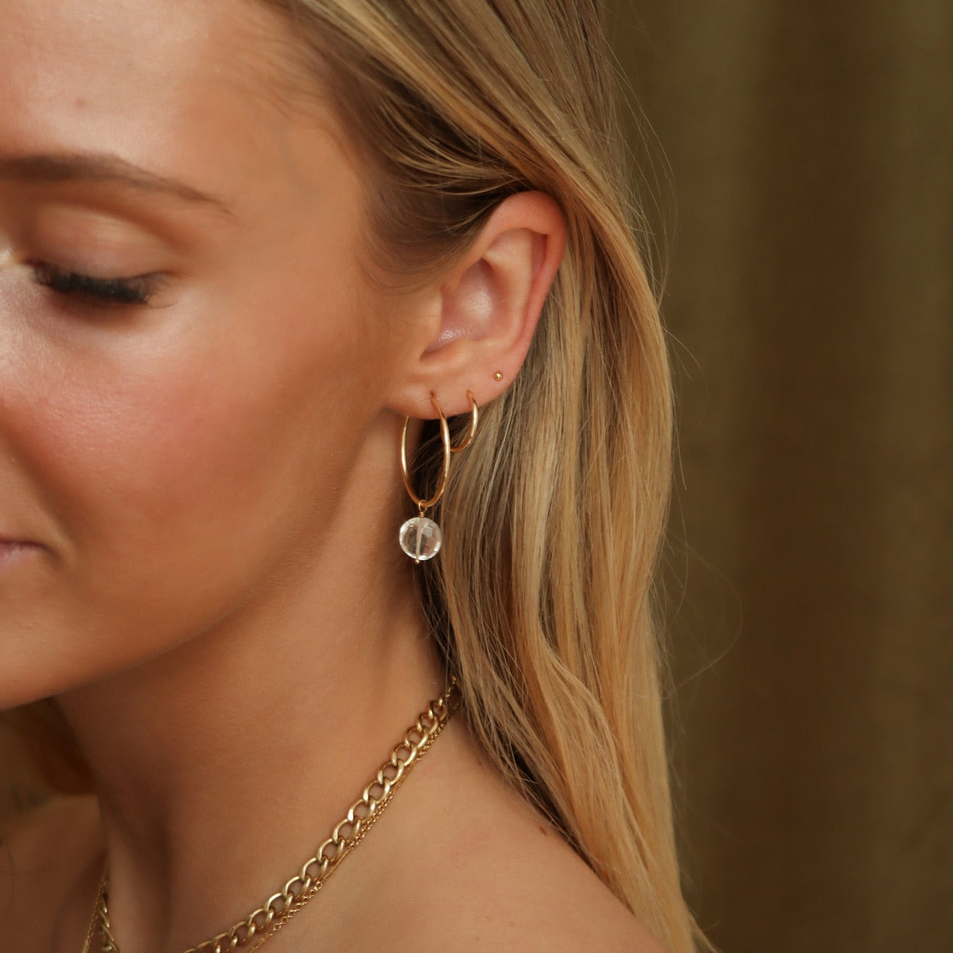 Handcrafted gold hoops adorned with faceted crystals for a subtle shimmer and timeless look.