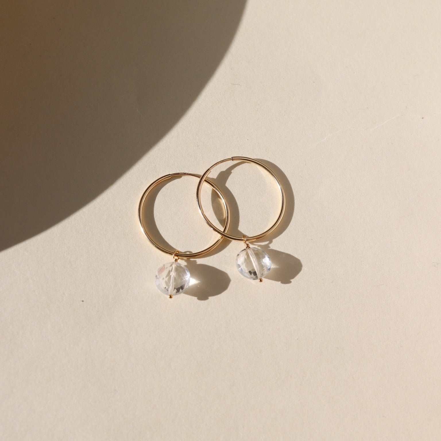 Faceted crystal hoop earrings in gold — elegant, lightweight hoops with sparkling crystal accents.
