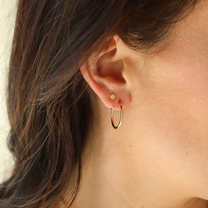 model wearing 14k gold fill hammered hoops paired with gemstone studs