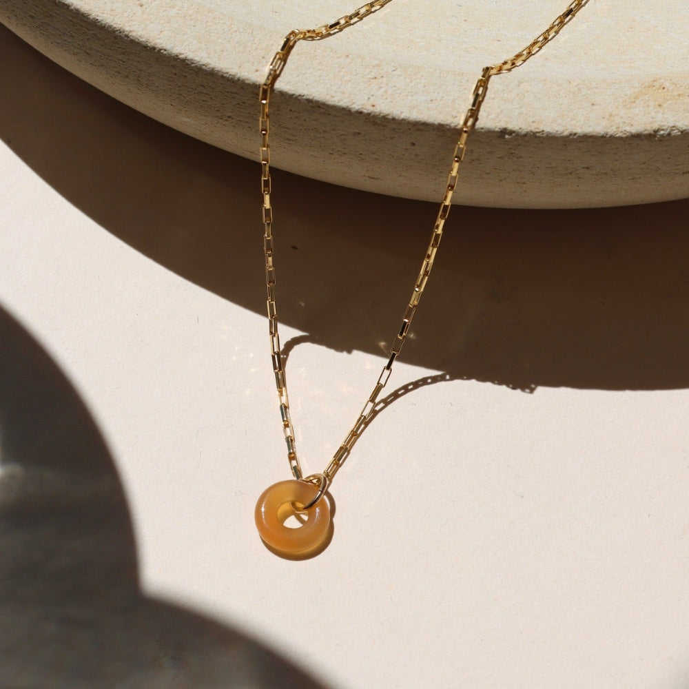 14k gold fill chain necklace with agate donut pendant on a light surface