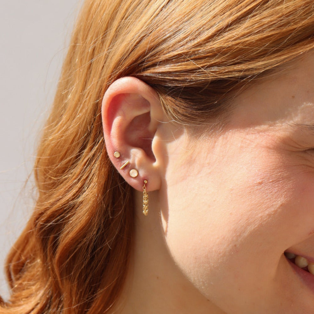 Model wearing a 14k gold fill textured rolo chain dropped from a classic ball stud
