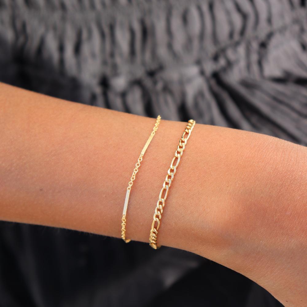 Model wearing 14k gold fill figaro chain bracelet with bar &amp; cable chain bracelet in 14k gold fill