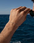 Model wearing La mer Bracelet in 925 sterling silver. next to the ocean.
