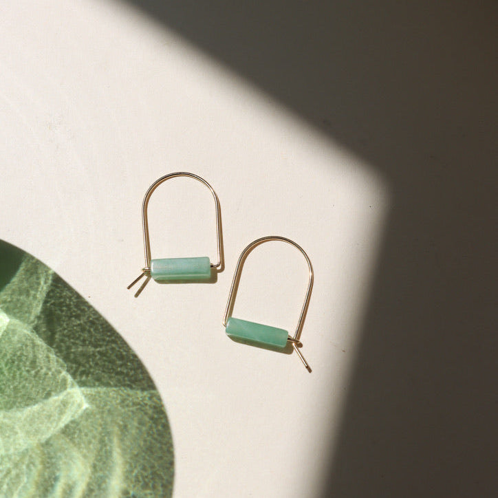 14k gold fill arch shaped earrings with aventurine tube beads on a light surface