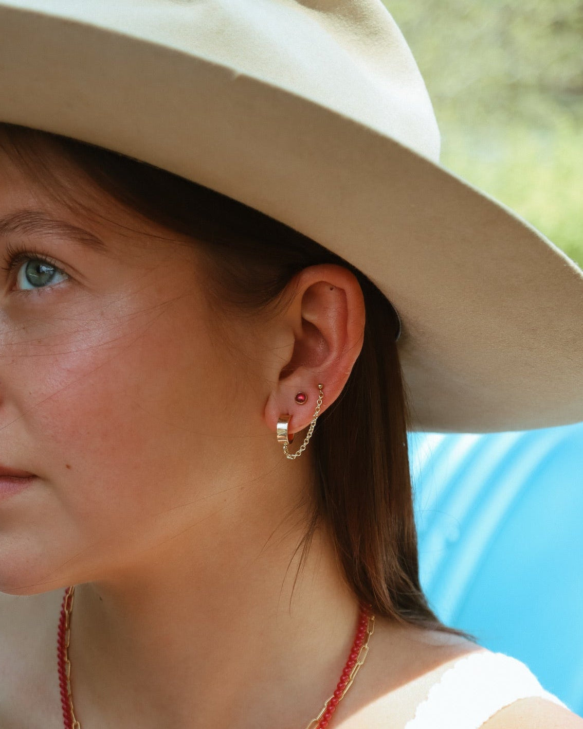 model wearing 14k gold fill chain studs with ruby studs