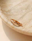 14k gold fill braided textured ring, displayed on a marble back drop 