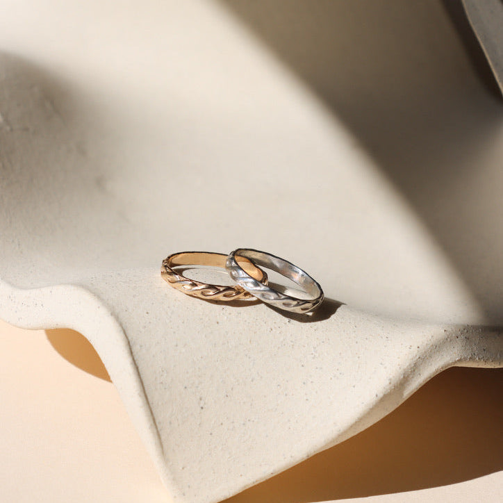 14k gold fill and sterling silver textured rings on a light dish