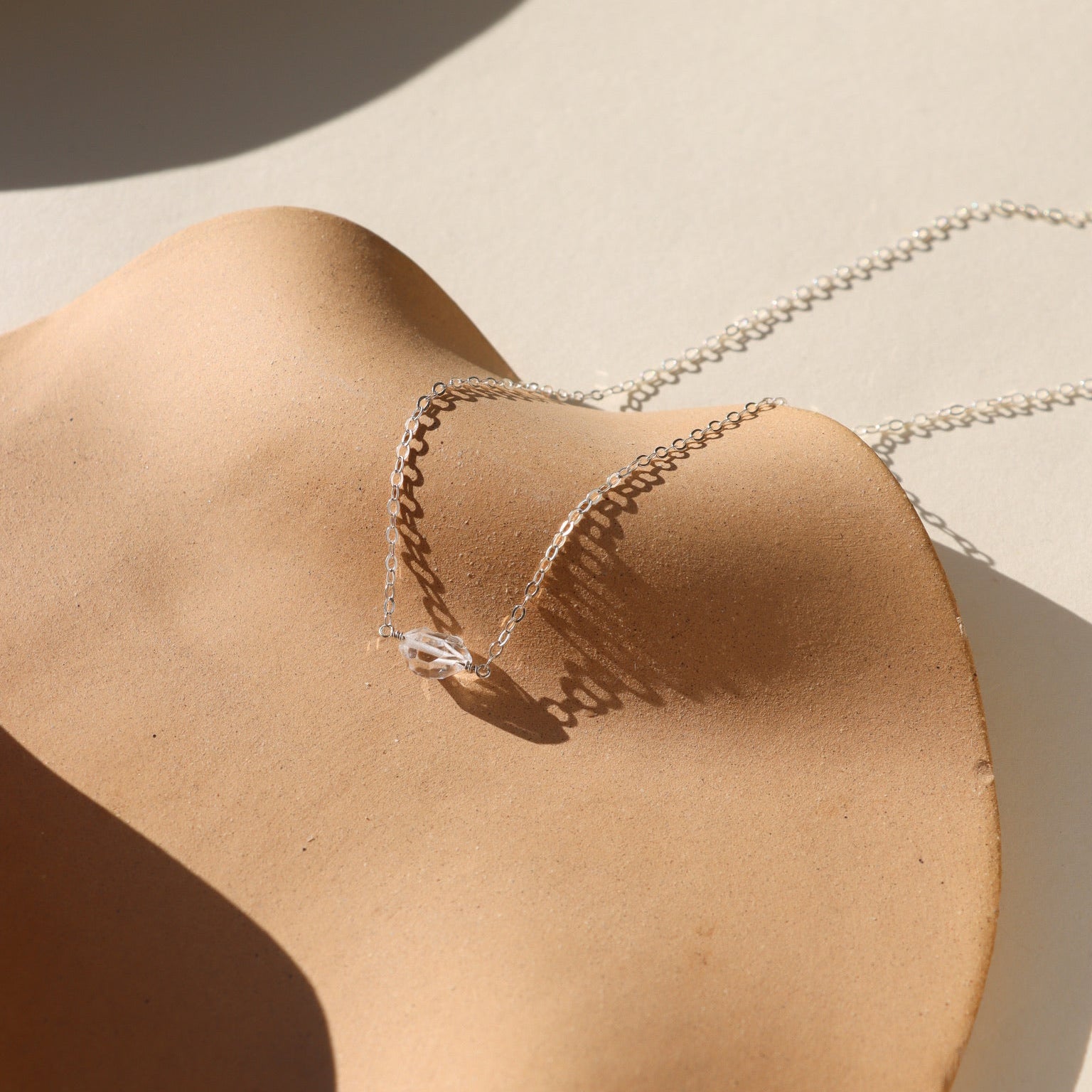 Herkimer diamond pendant necklace featuring a raw, double-terminated quartz crystal on a delicate sterling silver chain.