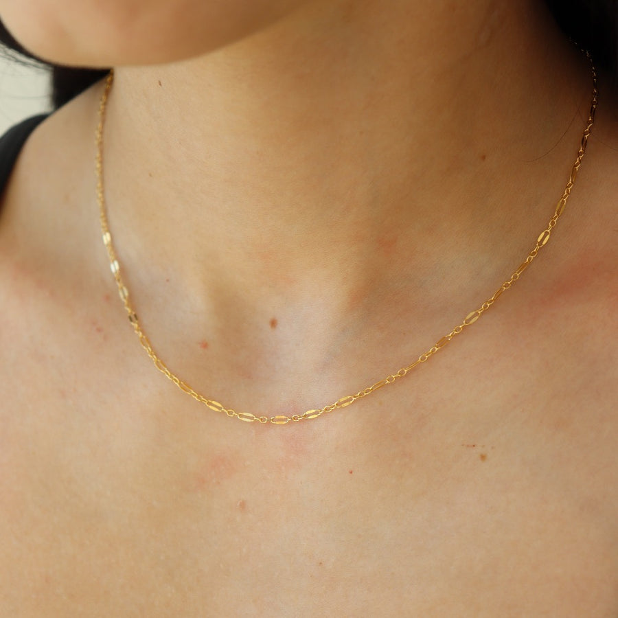 14k gold fill delicate chain, photographed on a brunette model wearing a black t shirt