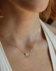 Model wearing 14k gold heart necklace on a 14k gold fill chain, photographed on a model