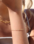 Model wearing 14k gold fill dot + dash bracelet
