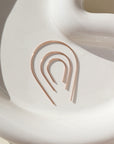 14k rose gold fill horseshoe shaped earrings photographed on a ceramic dish, handmade by Token Jewelry