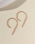 14k rose gold fill "nine" earrings laying side by side