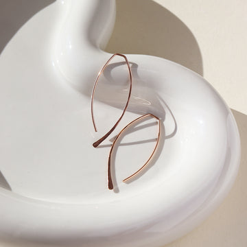 14k rose gold fill ebb and flow slide earrings, photographed on a sunny table, handmade in Eau Claire, Wisconsin by Token Jewelry