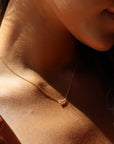 Model wearing 14k gold fill. This necklace features the simple chain and is then met together by three zircon stones.
