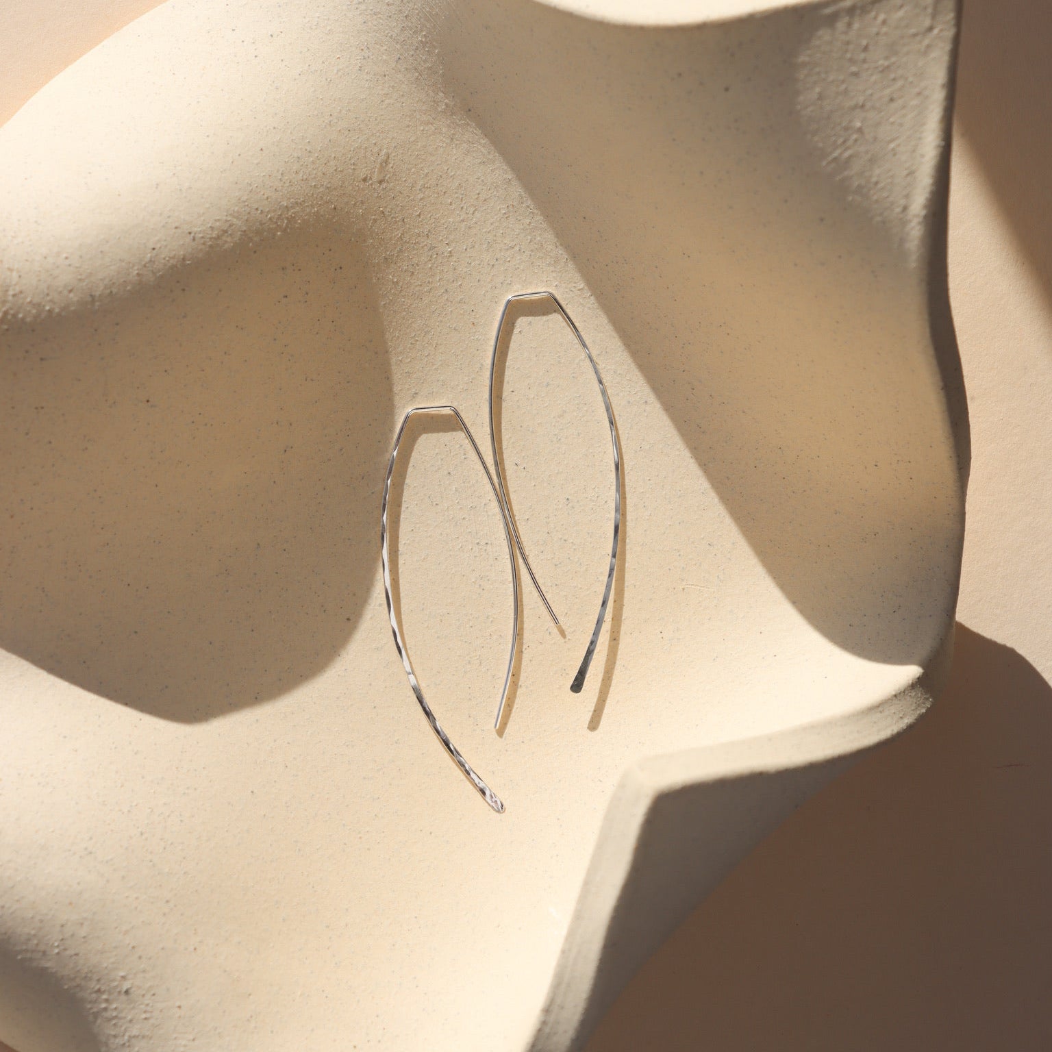 sterling silver ebb + flow slides laid on a wavy plate 