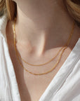 a 14k gold fill necklace made up of two chains, photographed on a model