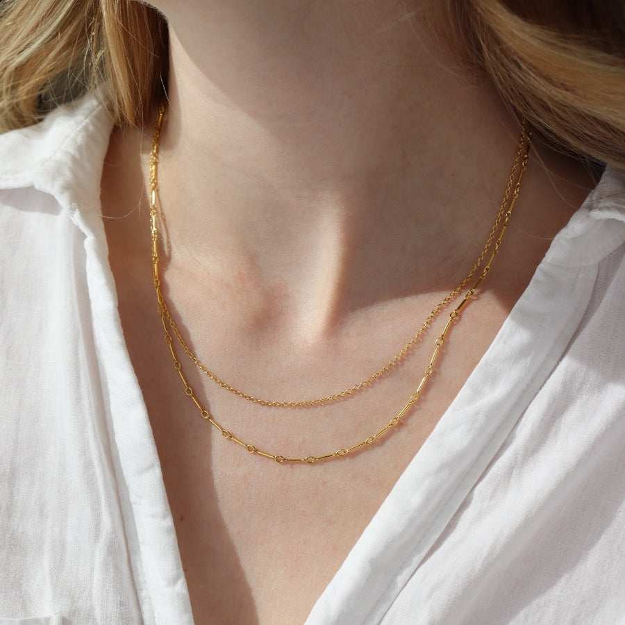 a 14k gold fill necklace made up of two chains, photographed on a model
