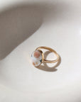 a 14k gold fill hand-set ocean jasper ring laid out on a cream colored backdrop in the sun