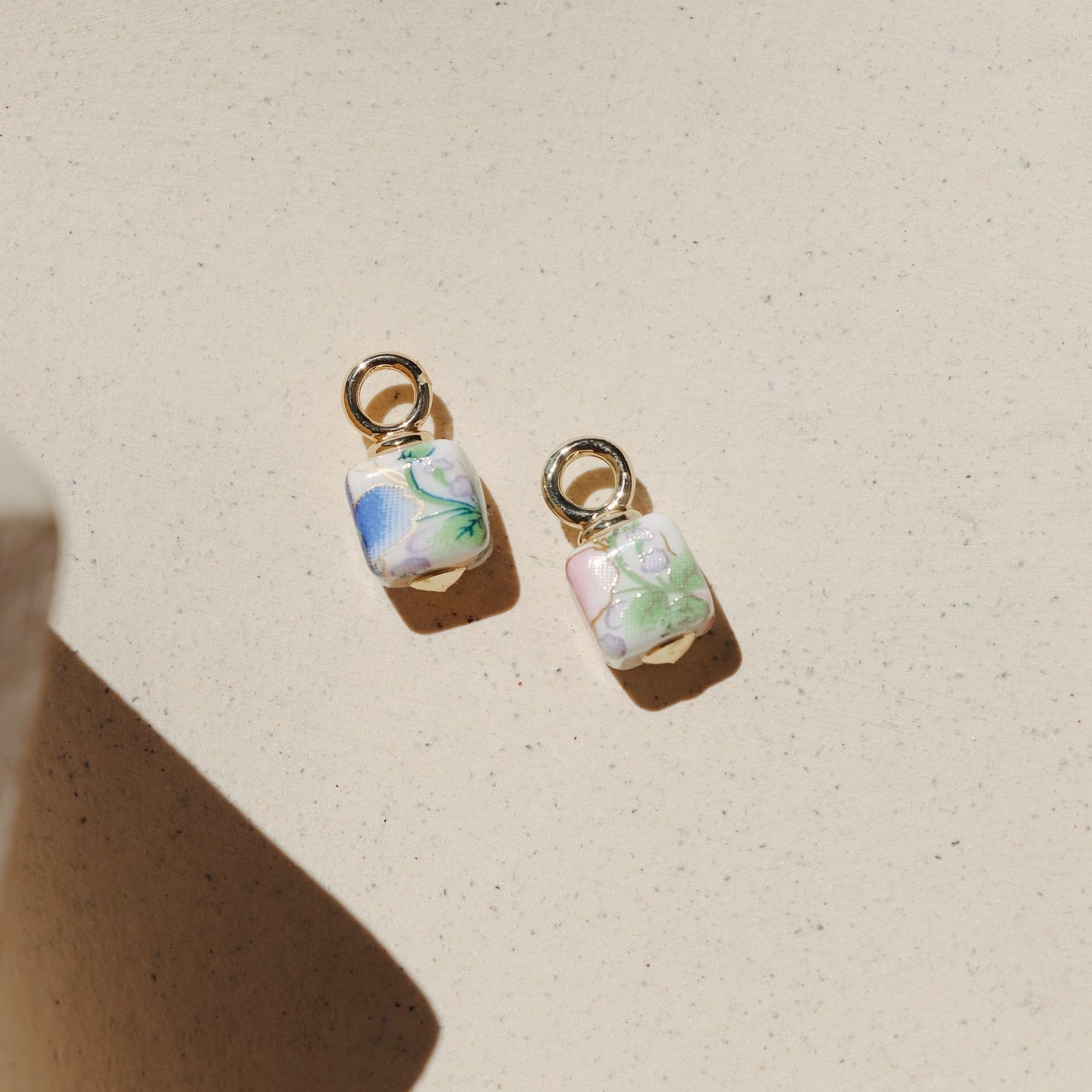 Floral ceramic cube charm with pastel vintage-inspired flowers and gold loop.