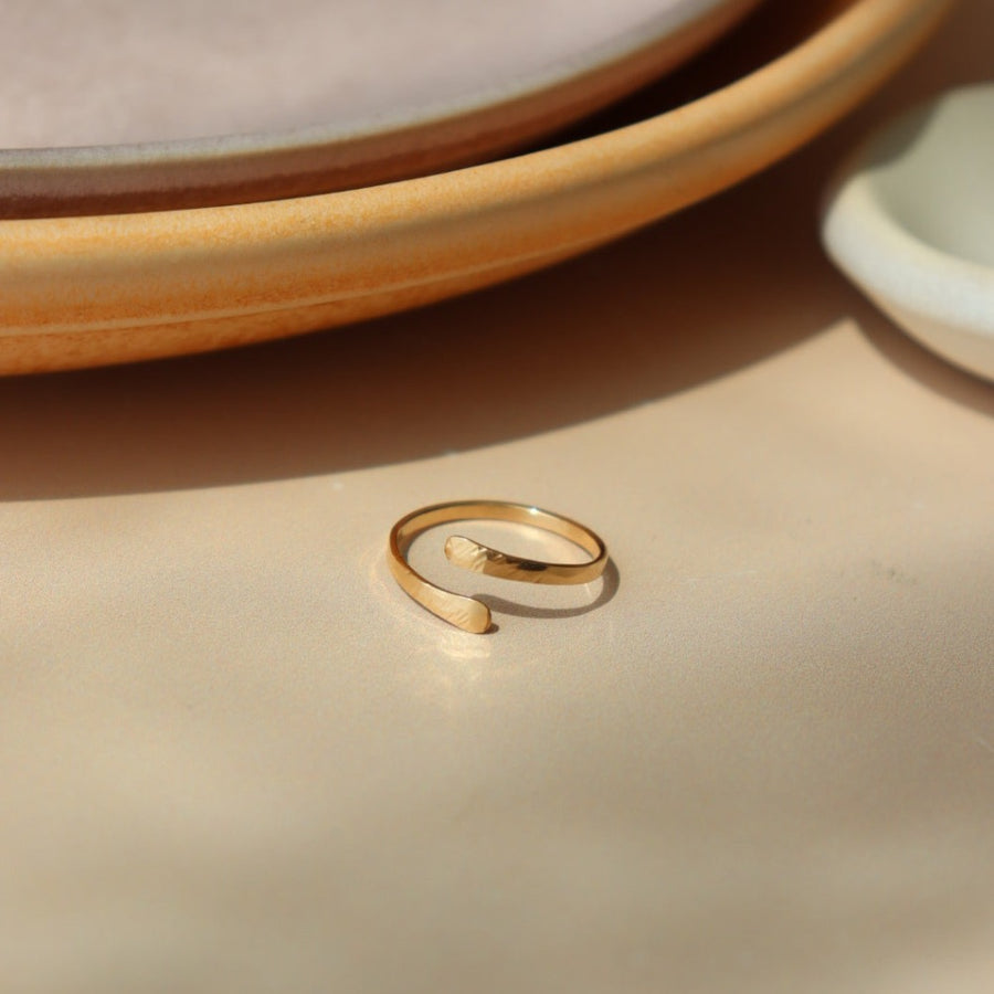 14k gold fill Textured Wrap Ring Laid on a peach plate. - Token Jewelry
