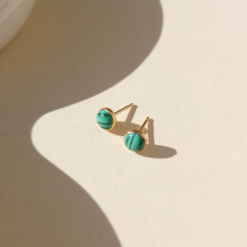 14k gold fill Malachite Studs placed in the sunlight. These Earrings feature Malachite gemstone.