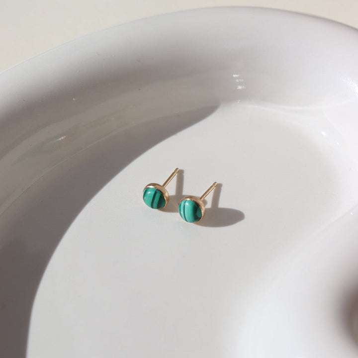 small stud 14k gold fill earrings with malachite stone photographed on a ceramic dish | handmade by Token Jewelry in Eau Claire Wisconsin