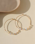 14k gold fill or sterling silver hoops, handmade and lightly hammered for shine, then adorned with six genuine australian opals that are delicately wire-wrapped. Handmade by Token Jewelry in Eau Claire, WI