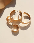 14k gold fill Florence hoops laid on a white plate in the sunlight