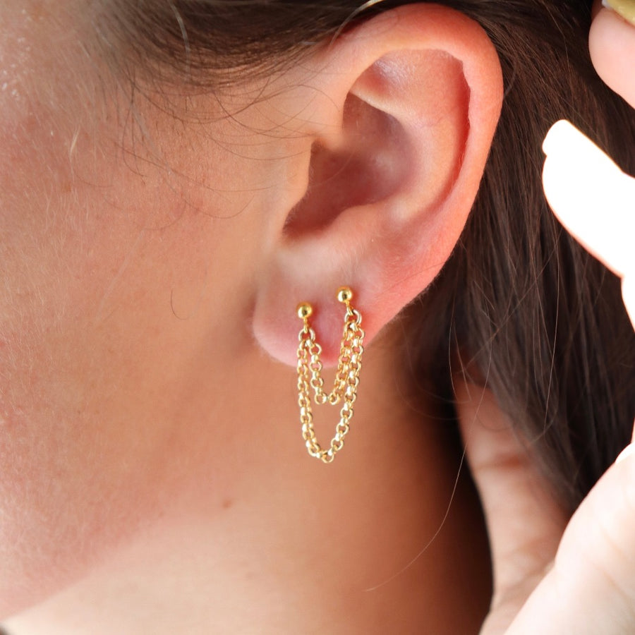 Model wearing 14k gold fill Dylan Double Studs hung up on a plant leaf. Handmade from Token Jewelry in Eau Claire Wisconsin. Hypoallergenic, nickel free. Perfect for everyday wear. - Token Jewelry