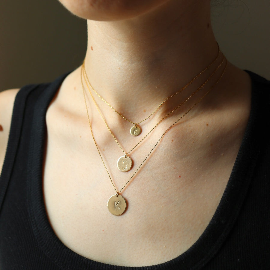 Model wearing all sizes of the monogram Coin Necklace